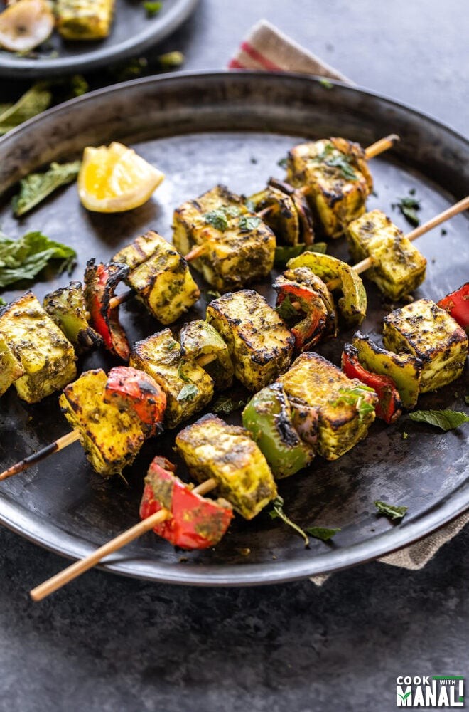 Five-Spice Paneer Tikka served on a plate with cilantro and lemon wedges