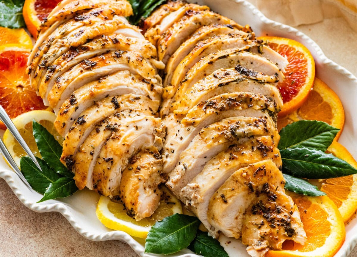 beautifully roasted herb-crusted turkey breast with carved slices and fresh herbs