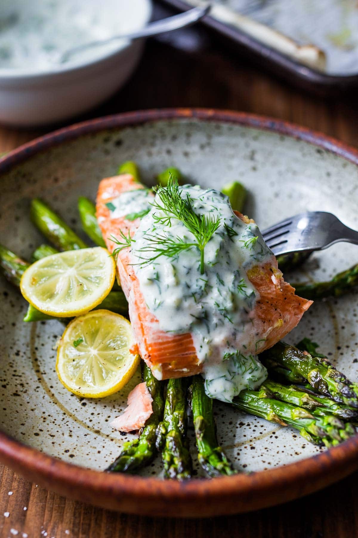Grilled fish fillets with creamy dill sauce, garnished with fresh dill sprigs