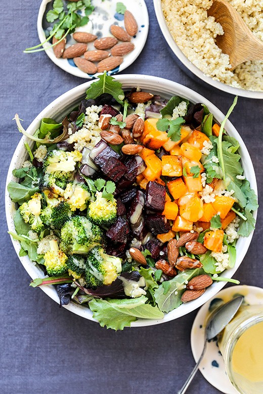 colorful roasted vegetables in a bowl with quinoa and avocado