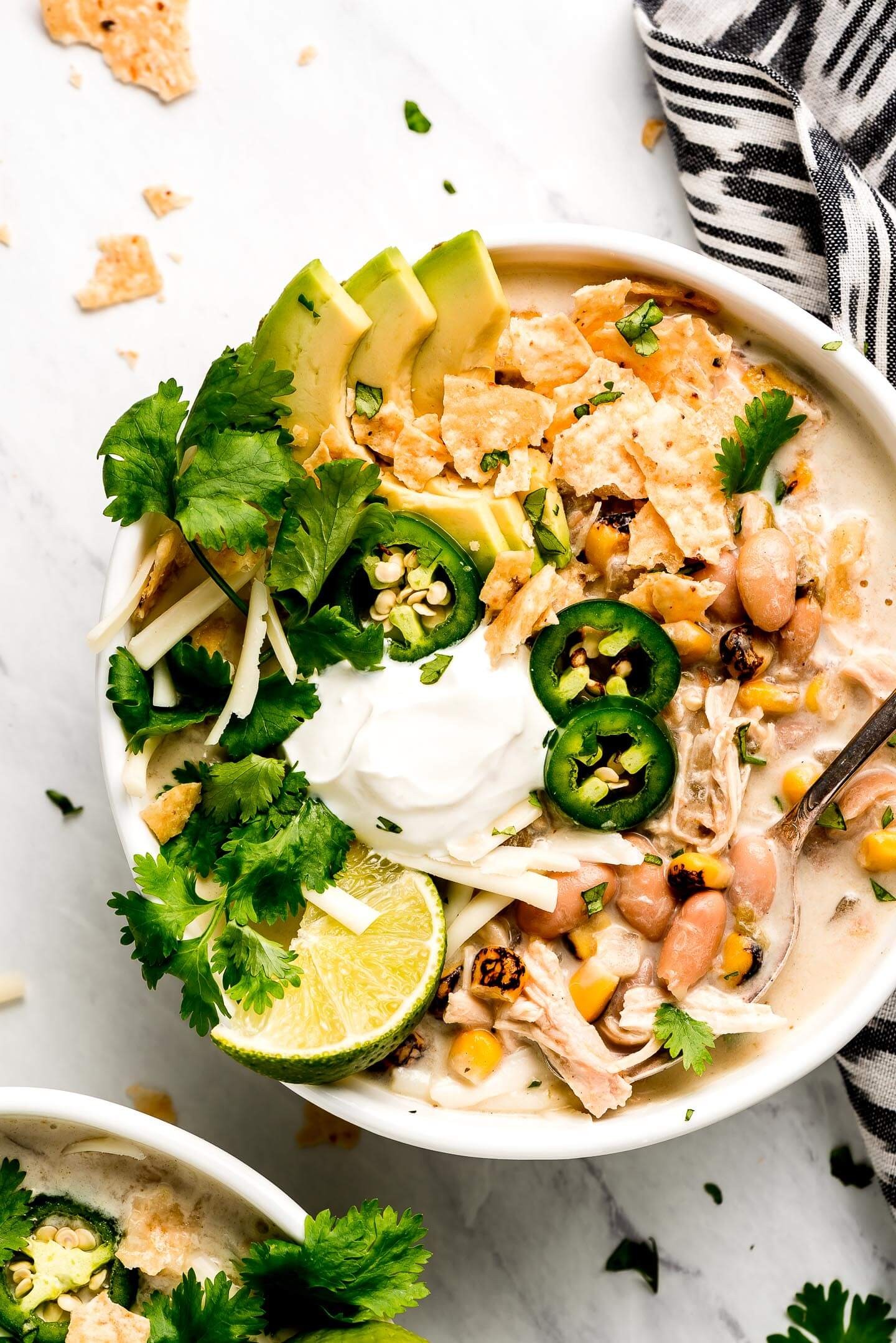 hearty white chicken chili verde in a rustic bowl, garnished with cilantro and sour cream