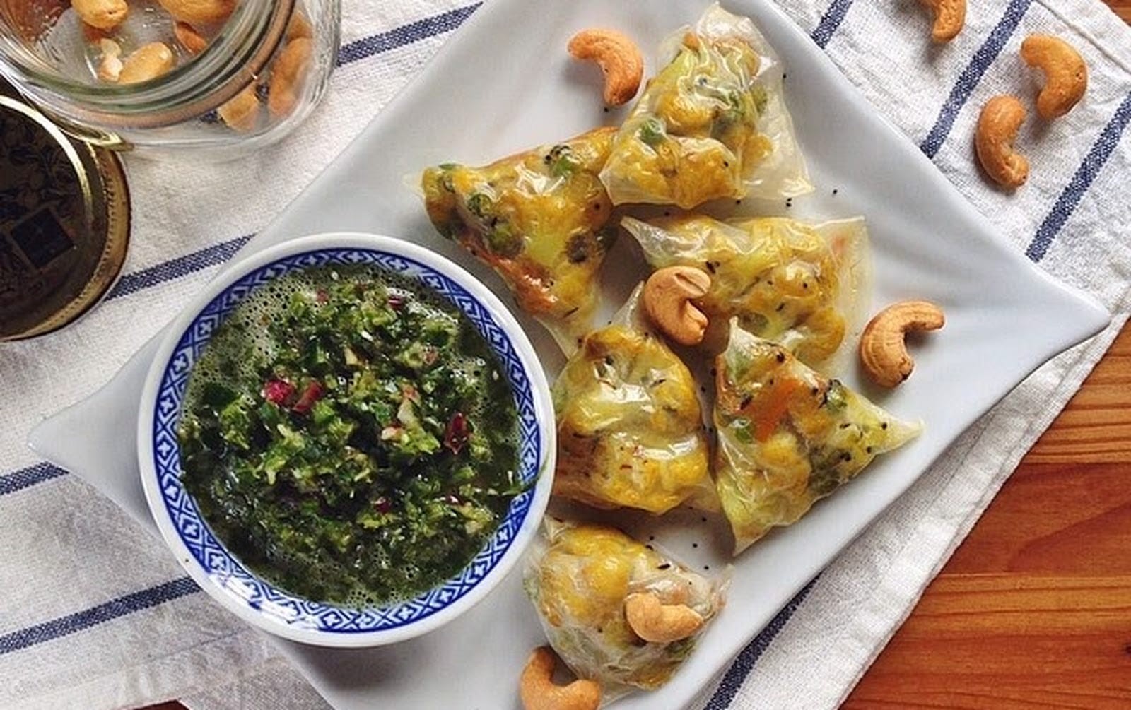 Cauliflower rice served with crispy samosas, garnished with fresh cilantro and a side of mint chutney