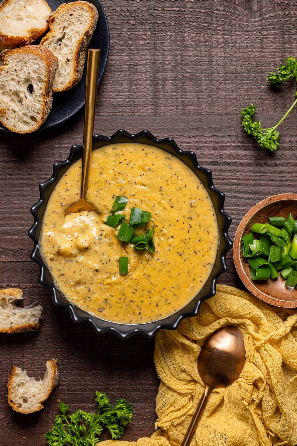 Hearty bowl of herb-loaded potato soup with crusty bread, cozy setting