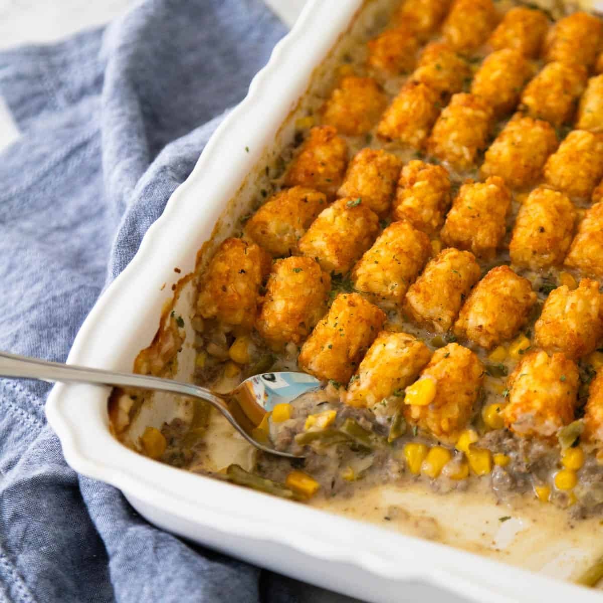 Warm and inviting ground beef creamy bake, golden brown cheese topping, a serving spoon ready to dish out