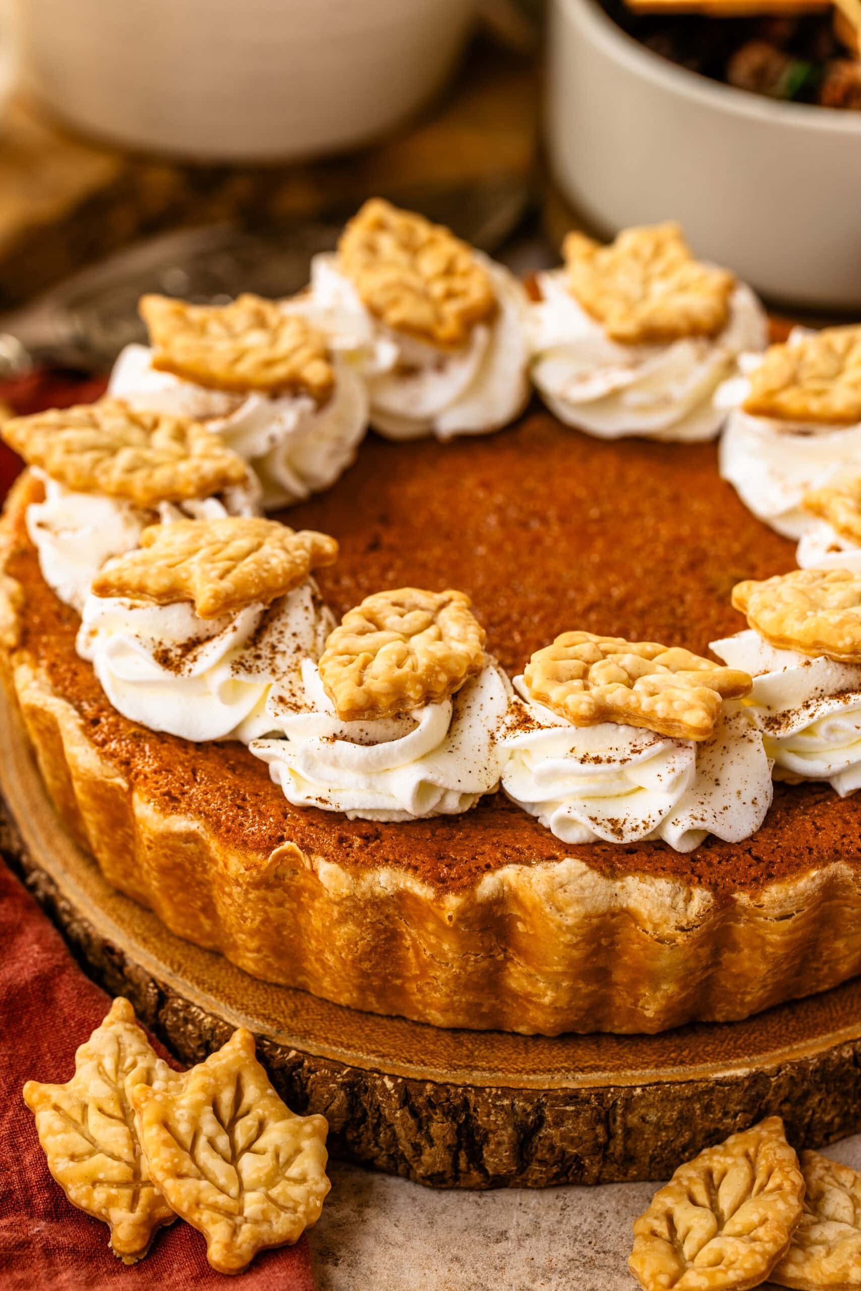 A beautifully baked sweet potato pie with a golden crust and smooth, creamy filling, garnished with a dollop of whipped cream on a rustic wooden table, cozy setting