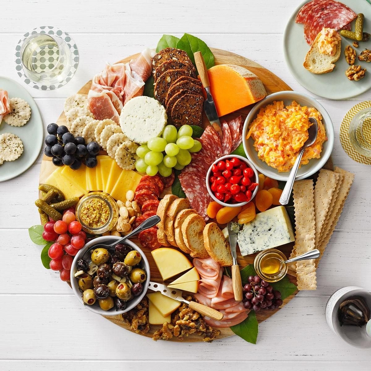 beautifully arranged charcuterie board with prosciutto, fig spread, cheeses, and grapes