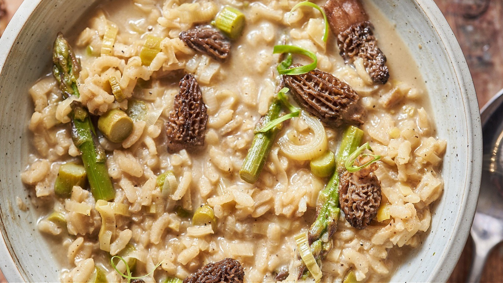 asparagus risotto with morels on a rustic wooden table