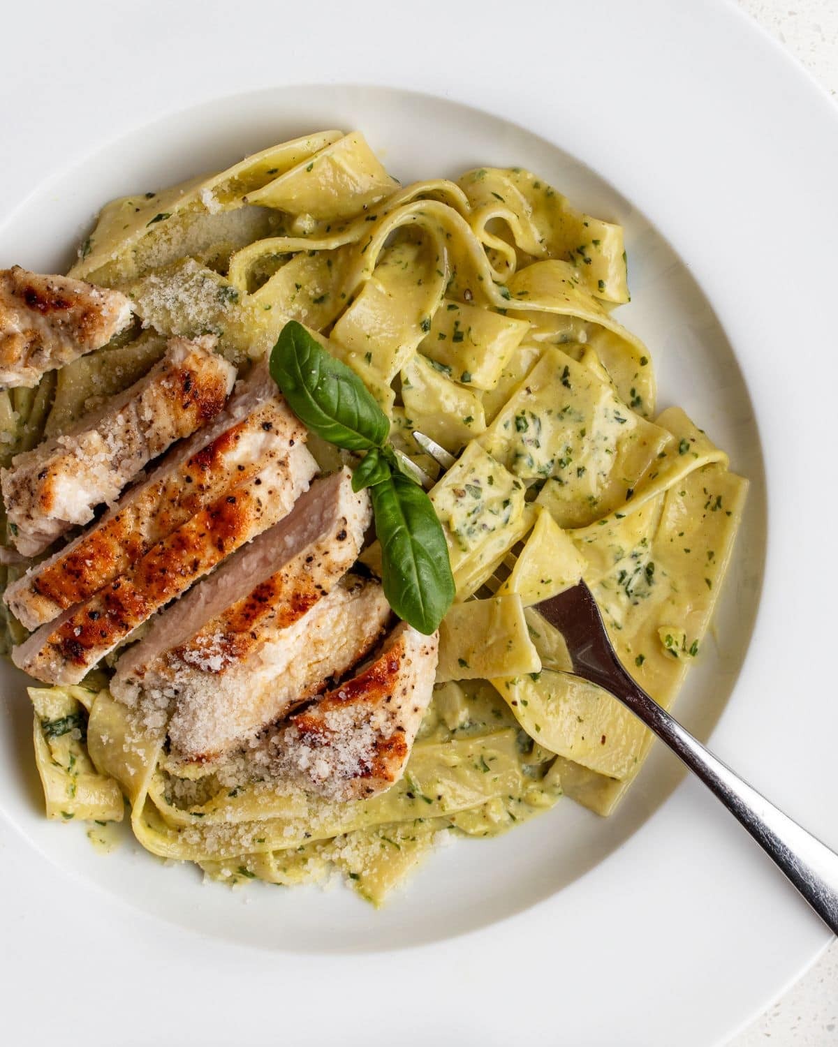 appetizing creamy pesto chicken with pasta on a plate