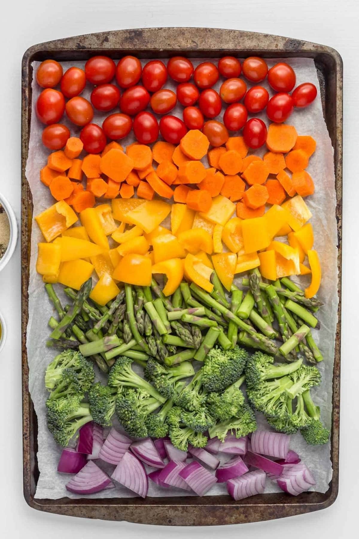 A colorful assortment of roasted vegetable sticks on a baking sheet
