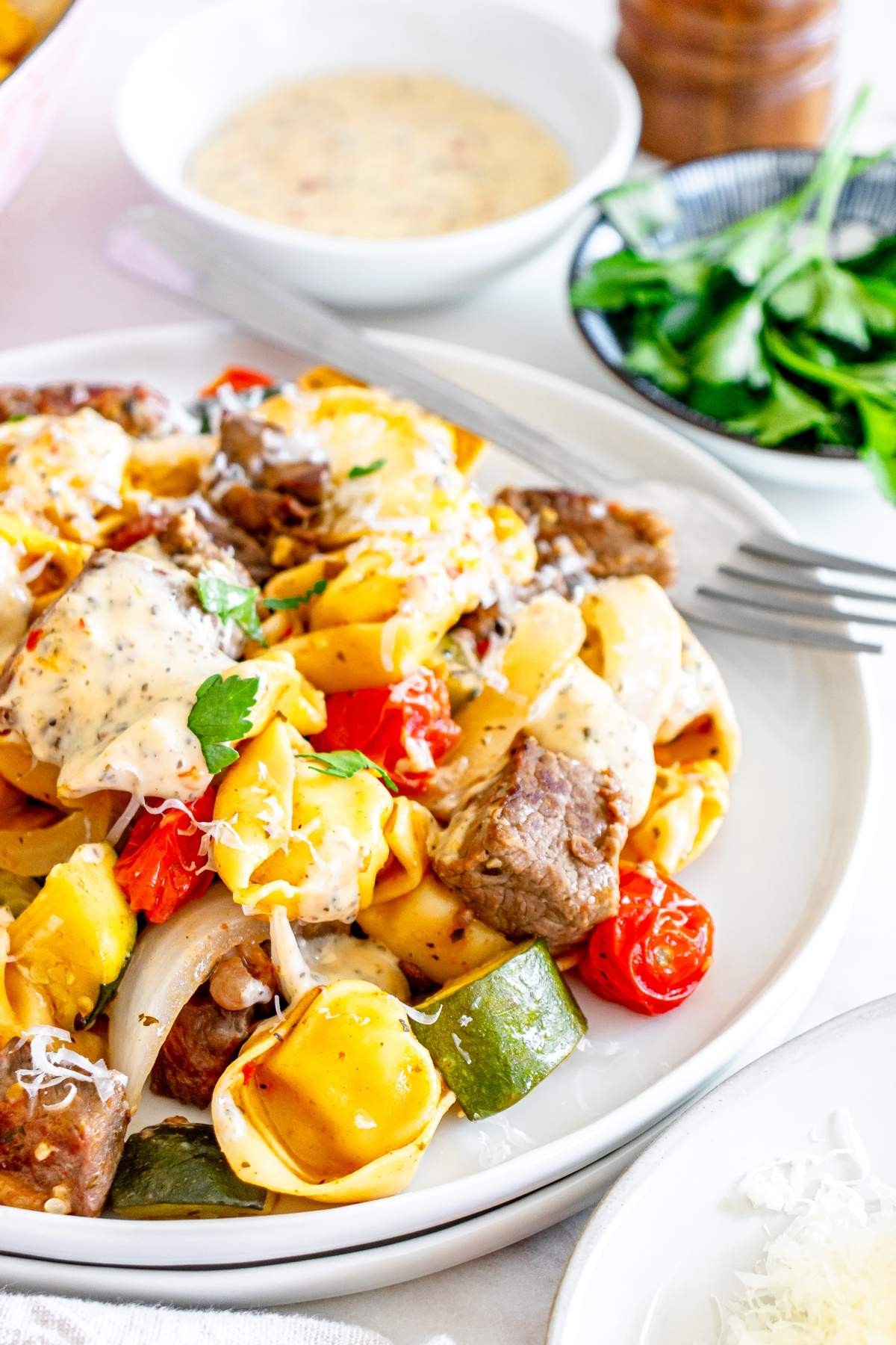 Garlic steak and cheese tortellini skillet, rich and creamy, garnished with fresh parsley