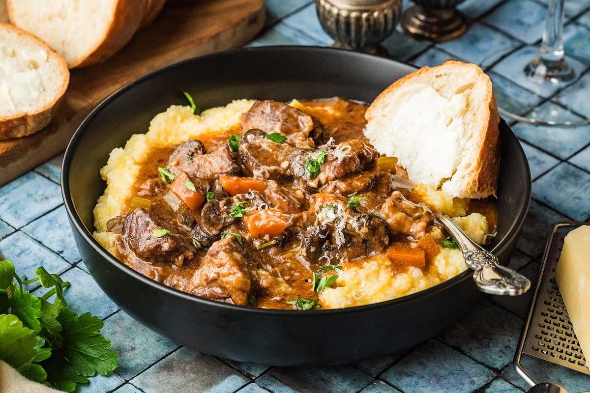 hearty chili garlic beef stew in a rustic bowl with crusty bread
