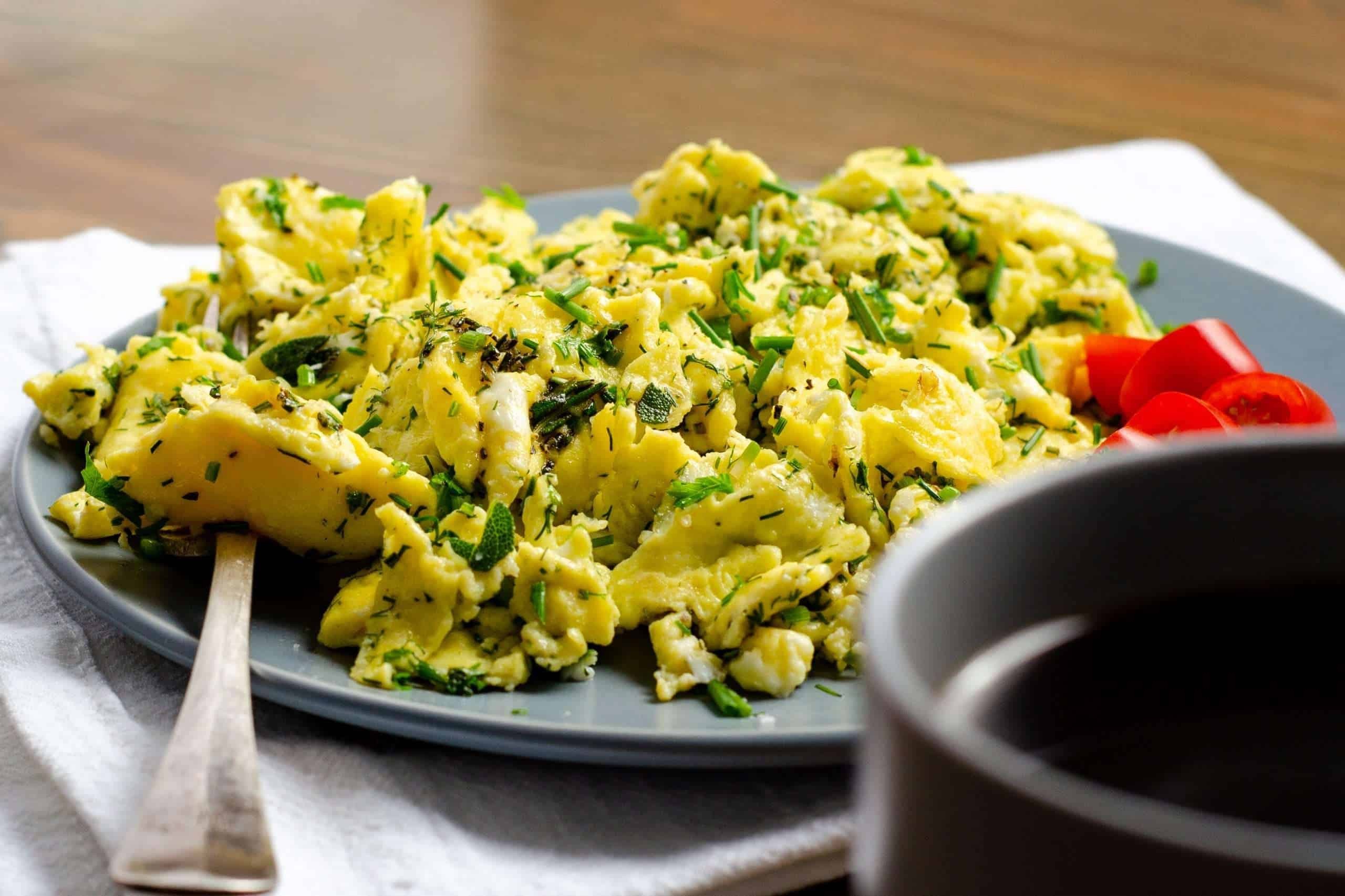 A delicious rosemary and egg scramble in a skillet, garnished with fresh rosemary sprigs
