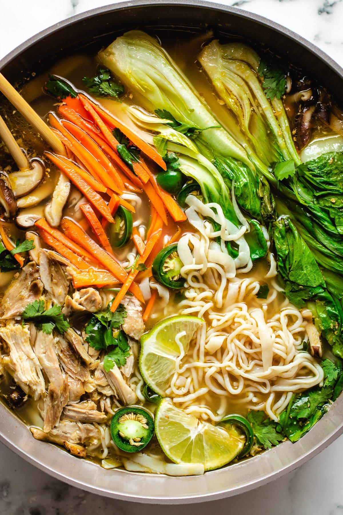 close up shot of vietnamese rice noodle soup with chicken and vegetables
