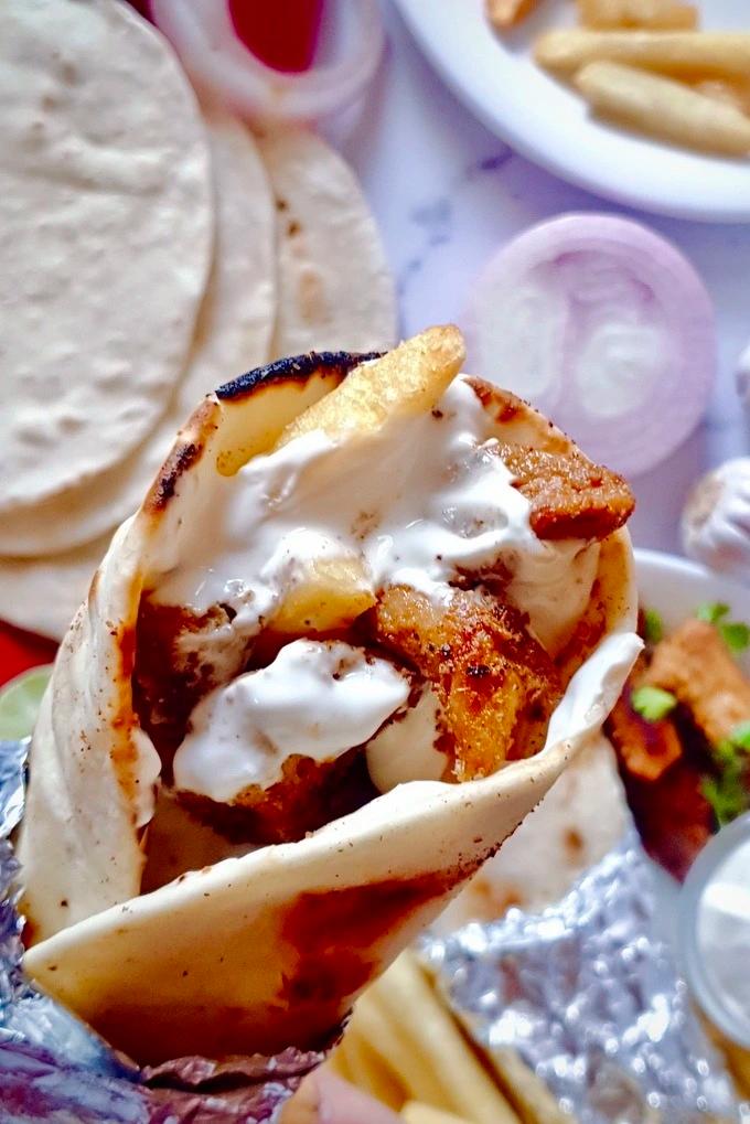 Close-up of juicy chicken shawarma in a warm tortilla