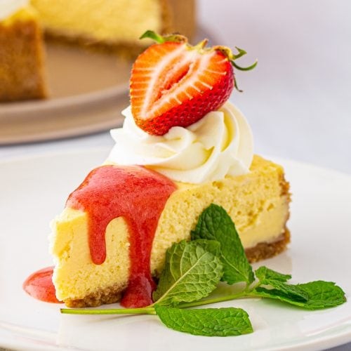 elegant vanilla bean cheesecake whole with a slice taken out, showcasing smooth texture, garnished with fresh berries