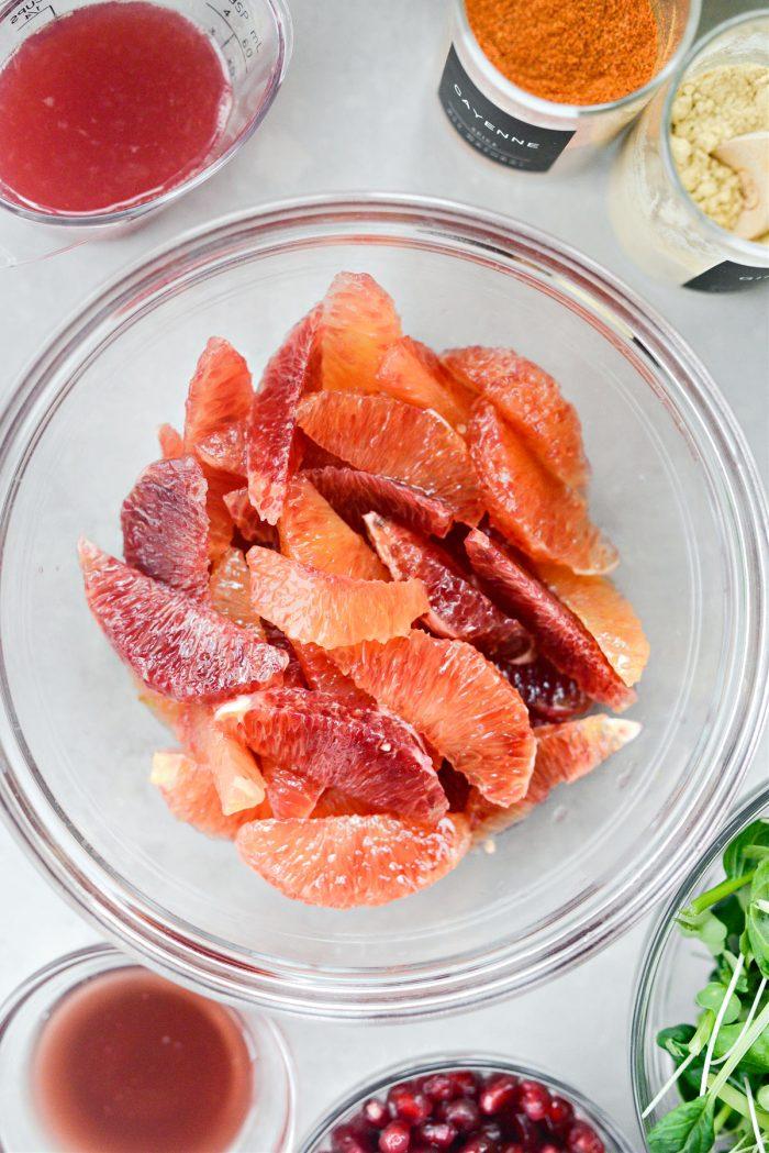 Close up of a bowl of Blood Orange & Pistachio Fattoush, highlighting the bright orange segments and green pistachios.