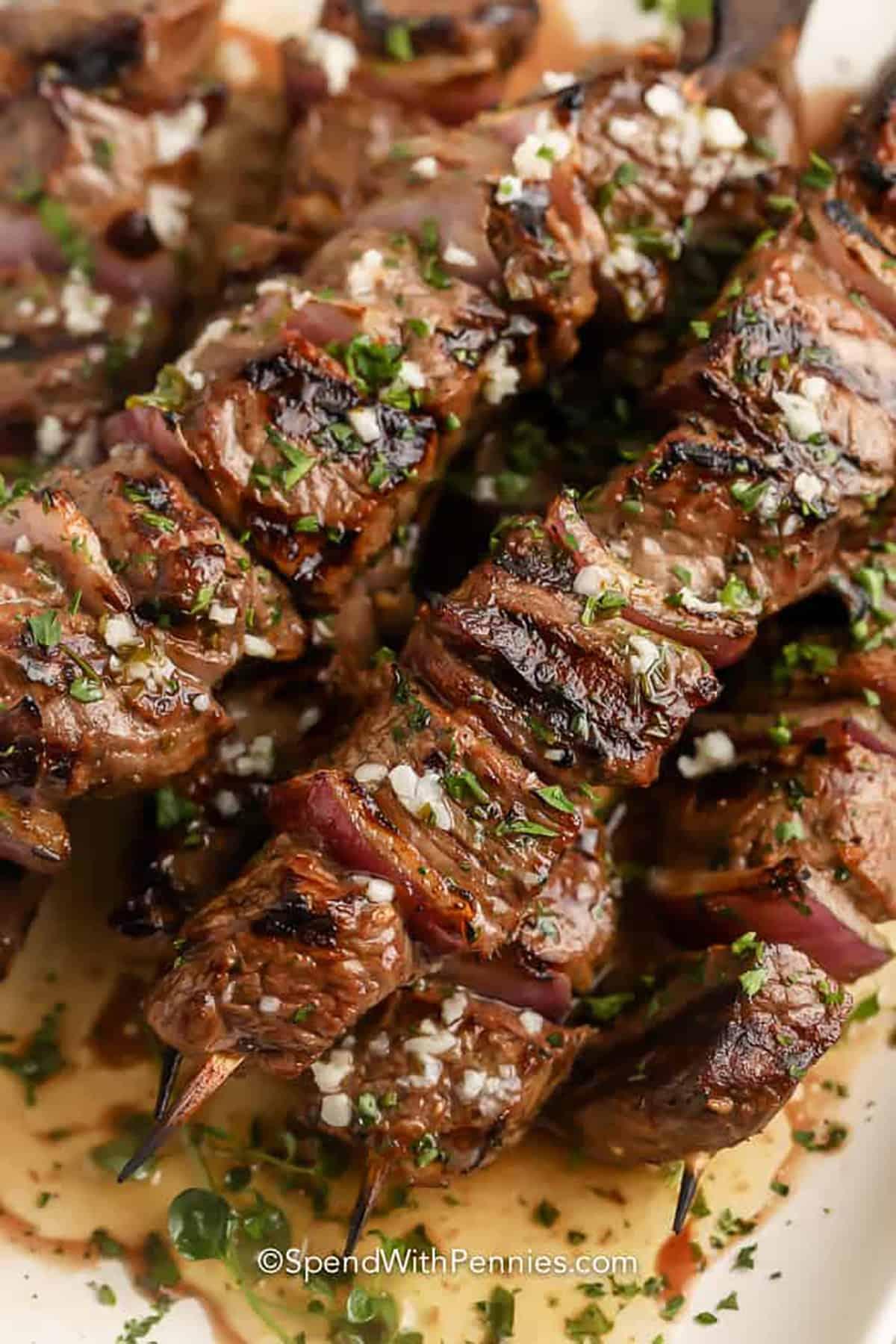 Close-up of juicy beef kebabs glistening with garlic herb butter